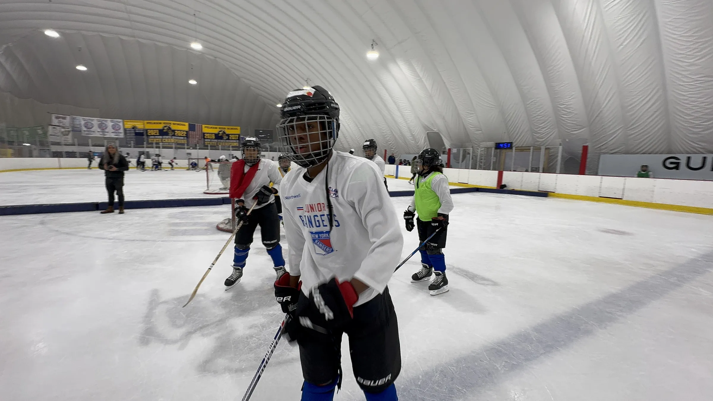 Young hockey player with full face mask on the ice